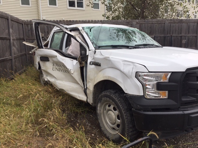Image of white Iowa State University truck with passenger side damage due to auto collision