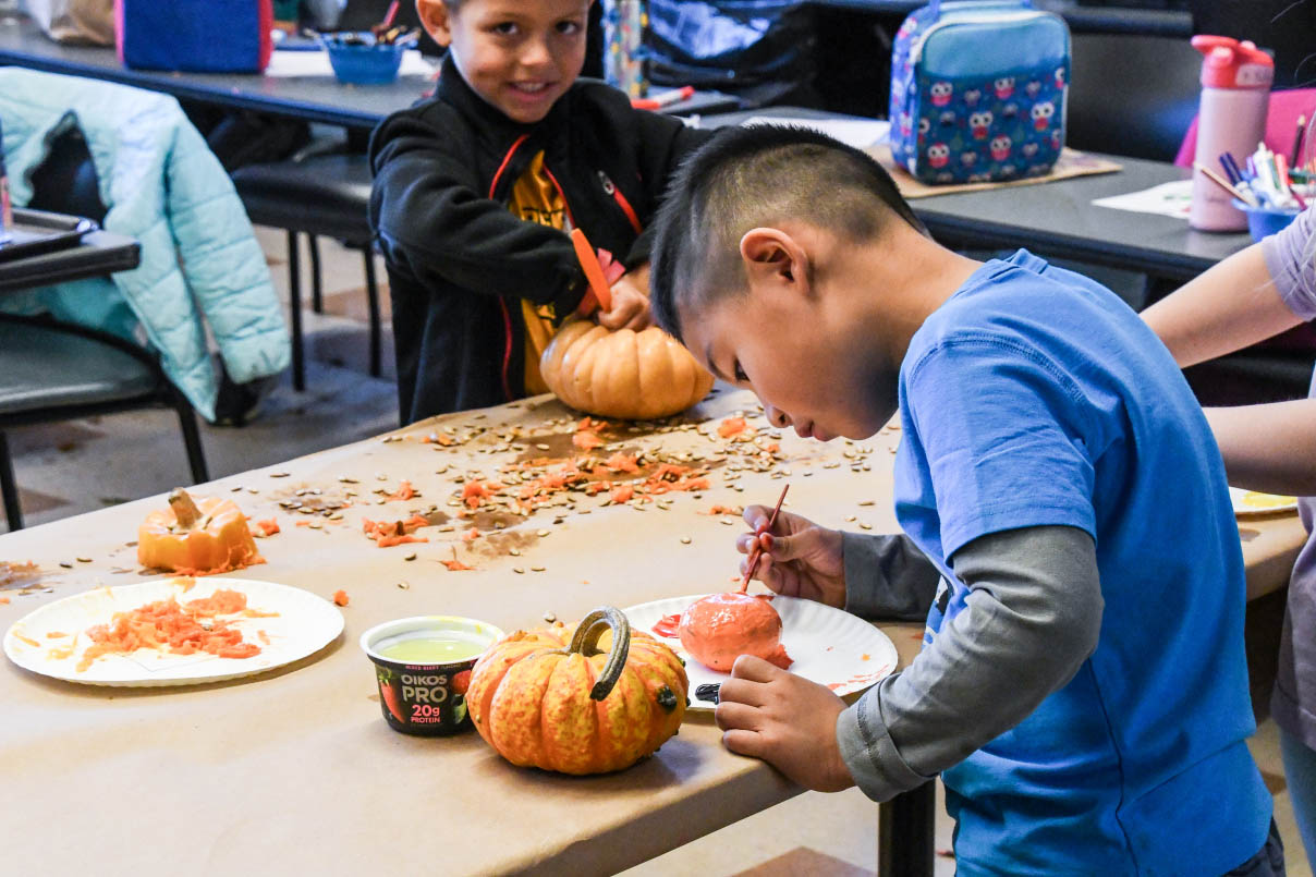 two children cleaning and decorating pumpkins
